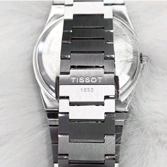 Tissot watch with silver and black band on a light gray background