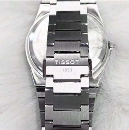 Tissot watch with silver and black band on a light gray background