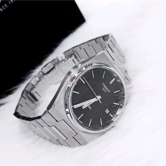 Silver watch with black face on a white background